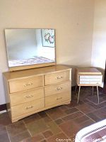 Six-drawer blonde oak dresser with attached rectangular mirror and small nightstand with tapered legs