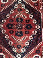 Close-up showing central geometric medallion design with maroon, navy, and cream colors and detailed motifs.