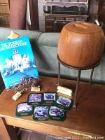 Overview photo showing all items: book, teak ice bucket on metal stand, coasters, brass calendar, and metal plant stand.
