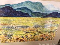 Framed watercolor painting showing mountain landscape and vibrant flower fields.