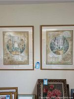 Pair of framed art prints hanging on the wall, showing full frames and the overall aesthetic of the lot.