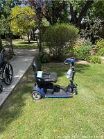 Side view of blue mobility scooter showing seat, deck and front wheel
