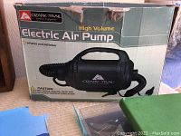 Ozark Trail electric air pump in original packaging with boxed size markings and caution label