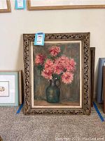 Full view of floral still life painting in ornate carved frame