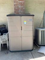 Front view of closed shed against exterior wall