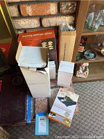 Photo showing multiple boxed items including K&H pet bed warmer package, a small white box, a long narrow box and a box with red graphics.