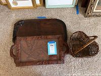 Three items on carpet: two wooden trays stacked, one with glass inset, and a heart-shaped wicker basket.