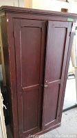 Front and side view of antique wooden cabinet with two paneled doors, showing condition and size.