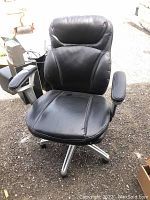 Front view of black rolling adjustable office chair with padded armrests and stitched panels.