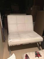 Front view of one white leather chair with metal base and tufted design.
