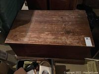 Top view of the wooden chest showcasing surface wear and damage.