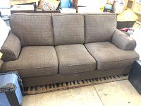 Full view of the 3 seater brown upholstered sofa, showing three seat cushions and rounded armrests.