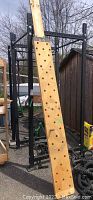 Assembled black steel rack with wooden pegboard leaning against frame