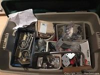 Photo of the full tote showing various hardware items inside, including boxes, loose pieces and metal parts.