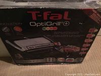 Original boxed T-fal OptiGrill+ electric grill showing branding and product features on box.
