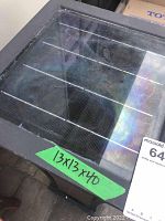 Close-up image of the solar panel on the top of the pillar light showing the solar cell grid behind the glass covering with label "13x13x40".