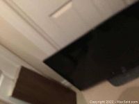 Partial side view of the LG TV screen and frame in a basement environment.