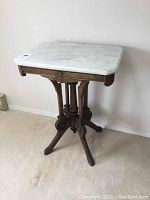 Front view showing full rectangular marble top and wooden base