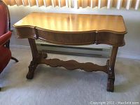 Front view of antique Victorian single drawer side table showing carved legs and stretcher base.