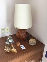Lamp with wood burl base and off-white fabric shade, also showing owl figurine, trinket box and pill box on table