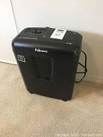 Front view of the black Fellowes paper shredder showing the transparent bin window and brand logo.