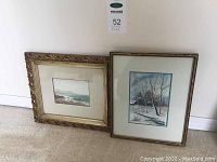 Two framed artworks against wall, showing size and framing style: one with decorative gold frame and smaller seascape, other with thin metallic frame and larger winter landscape.