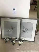 Two framed prints displayed on the floor with three bird figurines in front, showing overall lot contents and condition.