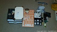 Overview of all items spread on carpet showing storage boxes, adapters, Apple power supplies, and miscellaneous items