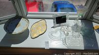 Overview of all items in lot, showing cake stand, etched platter, tea light holder, and various clear glass serving dishes arranged on windowsill.