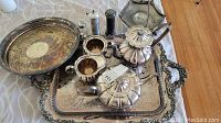 Image showing silver plated Melon Community Sheffield tea and coffee set with matching cream pitcher, sugar bowl, salt and pepper shakers, candy dish and two trays on fabric-covered table.