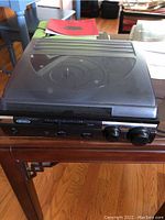 Full view of Jensen turntable with dust cover closed on wood table