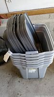 Stacked gray plastic tubs, showing quantity and condition
