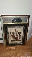 Four framed wall art pieces including one papyrus print with Egyptian scene, and others with varied artwork and materials