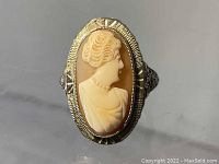Front view showing the detailed carved woman's profile cameo in the oval bezel setting.