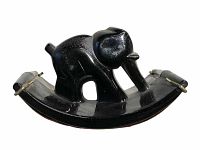 Front side view showing glossy black glass elephant figure on a curved base with roller blotting pads.