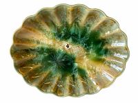 Top-down view of the platter showing its scalloped edges and multi-tone green and brown glaze pattern.