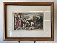 Framed hand colored antique print depicting Doctor Syntax with horse and companions in a village scene with a church in background.