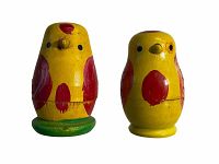 Front view photograph of two larger hand-painted yellow and red wooden nesting birds, one with green base.