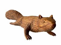 Front side view of the hand carved wooden squirrel, showing detailed facial features and paws with textured fur.