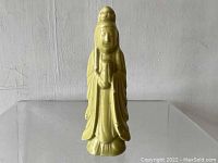 Front view of yellow glazed ceramic Kuan Yin statue showing full figure standing in robes with hands held in front.