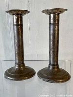 Front view of two weighted sterling silver candlesticks side by side.