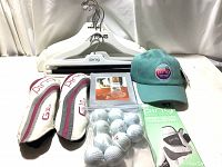 Photo shows Ping G Le 2 headcovers, golf balls, Ping hat, golf glove in packaging, hangers, and golf stir sticks laid out for condition and completeness evaluation.