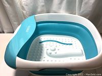 Top view of the blue and white collapsible footbath showing textured Acu-Node surface inside for massaging feet.