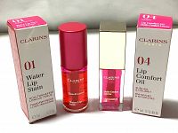 Photo shows both Clarins lip products side by side with their original packaging: Water Lip Stain 01 Rose Water and Lip Comfort Oil 04 Candy, each 7ml.