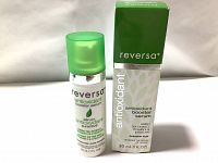 Photo of the Reversa antioxidant booster serum bottle with green translucent cap and box, showing front labeling including ingredients of green tea extract, vitamin E, and ß-glucan.