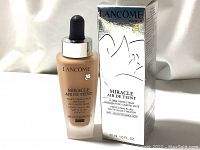 Front view of foundation bottle and box showing product name and branding.