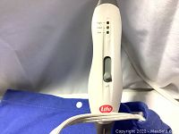 Close-up of control unit with Life Brand logo, showing adjustable heat settings: high, medium, low.