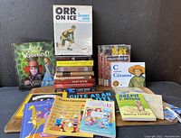 Shows Orr on Ice book by Bobby Orr alongside a group of children's books and Shadow of The Bat Collector's Sets, plus the poster folded beneath.