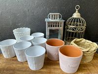 Lot contents including bird cage, lantern, milk glass bowl, various white ceramic pots, herb pots, and ceramic decorative item