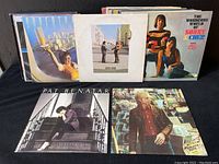 Six rock vinyl records from the 60s-70s arranged in two rows, shows album covers including Pink Floyd and Sonny & Cher